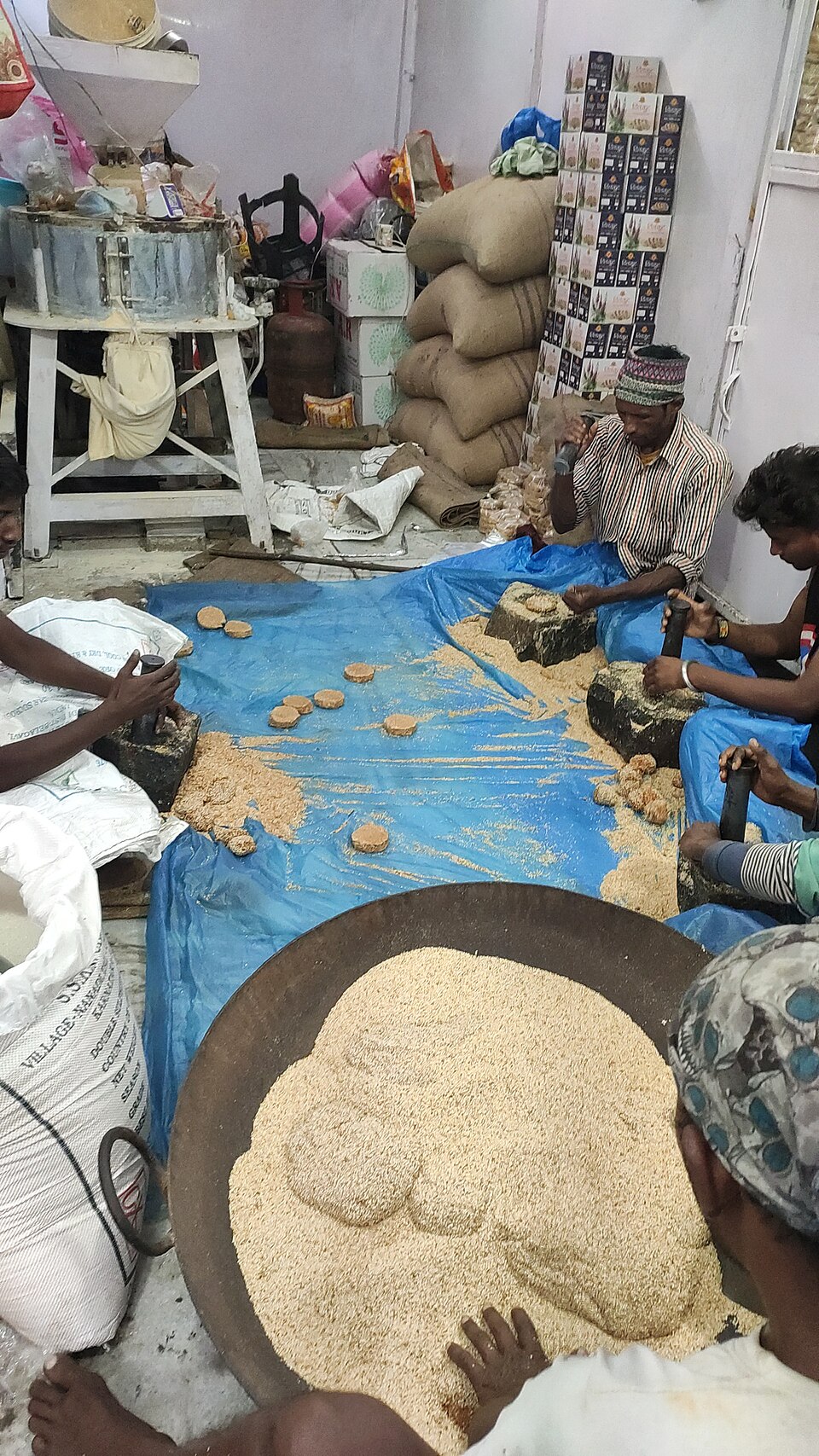 Workers pounding sesame and jaggery into tilkut discs
