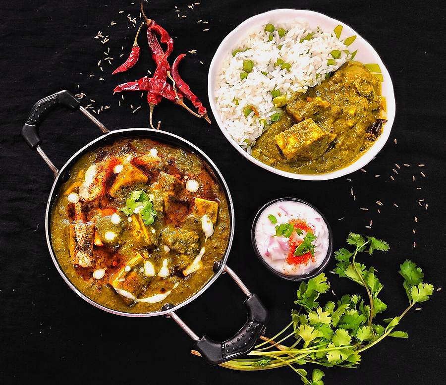 Palak paneer in a kadhai with cumin rice and onion raita