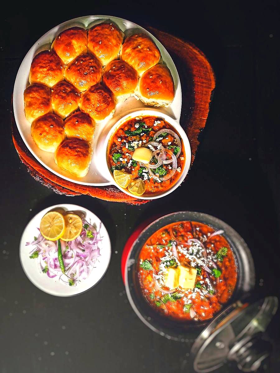 Pav bhaji with buttered pav, chopped onion and lemon
