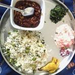 Rajma with jeera rice, saag and raita on a steel thali