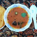 A bowl of rasam served with papad